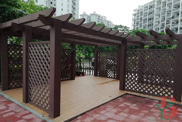 Dark brown WPC pergola featuring composite lattice panels for privacy screening