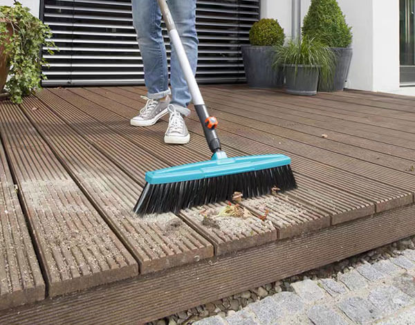 routine-maintenance-composite-decking-sweeping using a firm bristled broom to sweep leaves and debris off or daily composite decking maintenance.