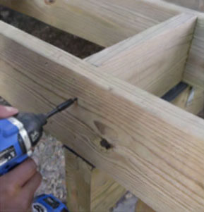 Along the end joists, use deck screws to attach extra bracing between the floor joists and end joists to mount the anchors.