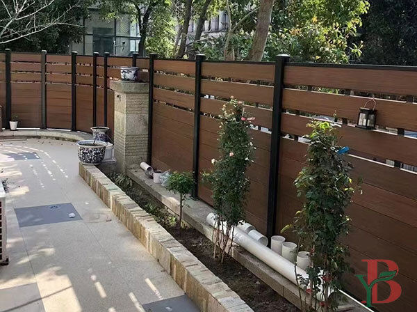 Modern Bongywood horizontal slat composite fencing with black posts providing privacy for a residential walkway