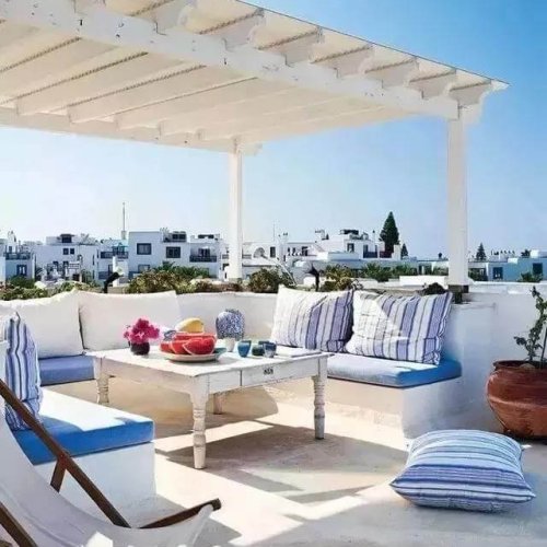 Modern white WPC pergola on a rooftop terrace with Mediterranean style outdoor seating.