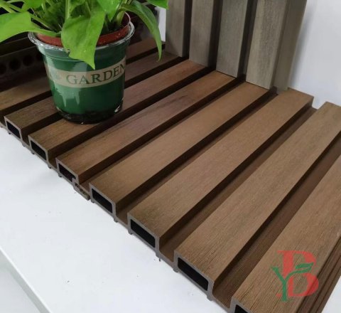 Close-up of brown co-extrusion WPC fluted panel showing realistic wood grain