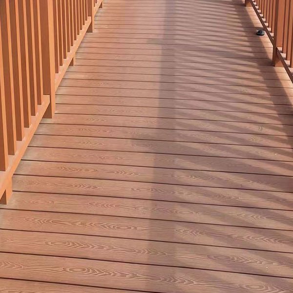 Close-up view of reddish-brown 3D embossed composite deck boards showing realistic wood grain texture.