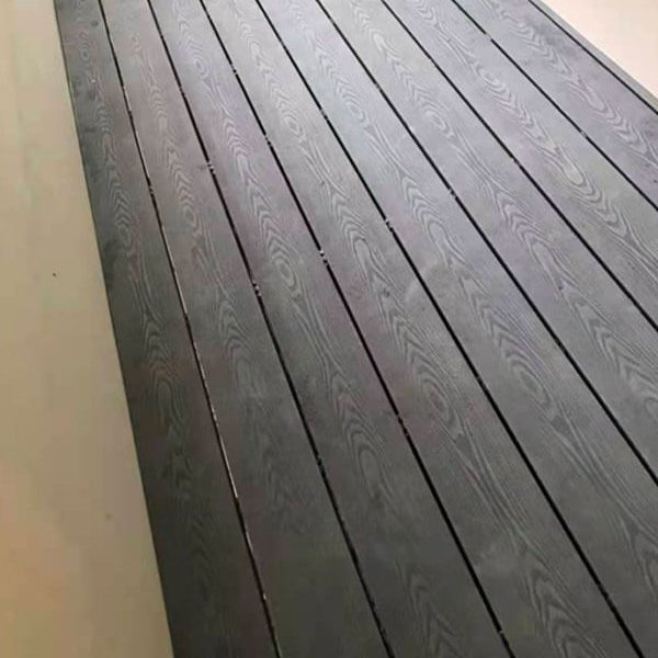 Close-up texture detail of dark grey 3D embossed composite decking boards
