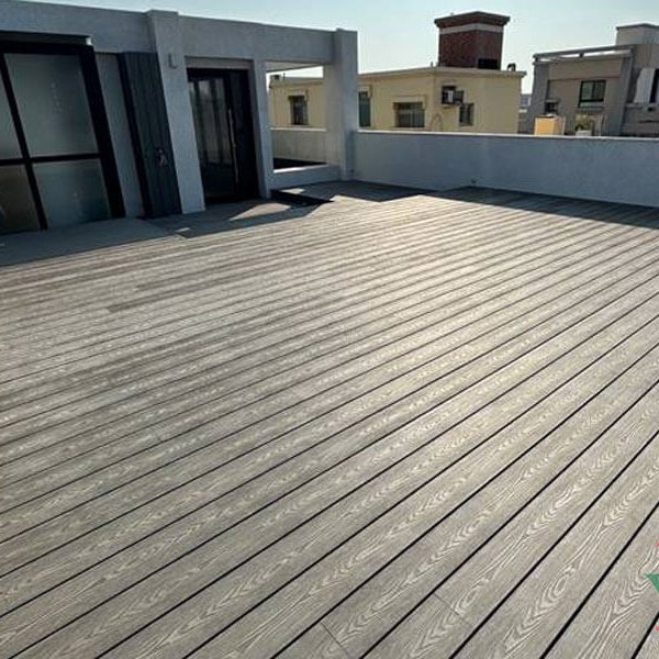 Close-up texture of high-quality gray composite decking on a large outdoor urban balcony.
