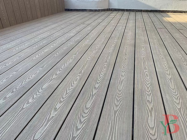 Close-up detail of grey 3D embossed wood grain composite decking texture