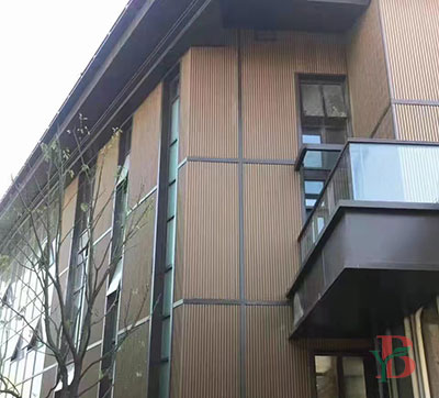 Vertical WPC composite wall panels on a multi-story commercial building facade.