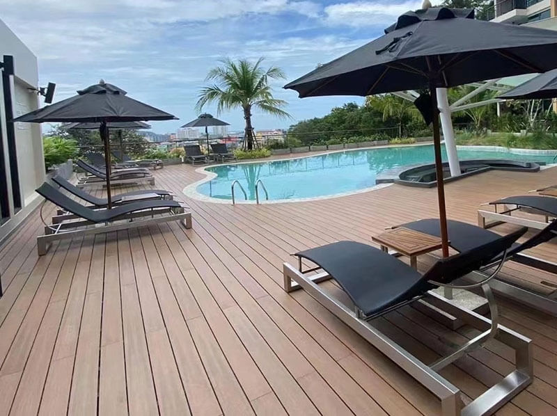 Slip-resistant capped composite decking installed around a luxury swimming pool