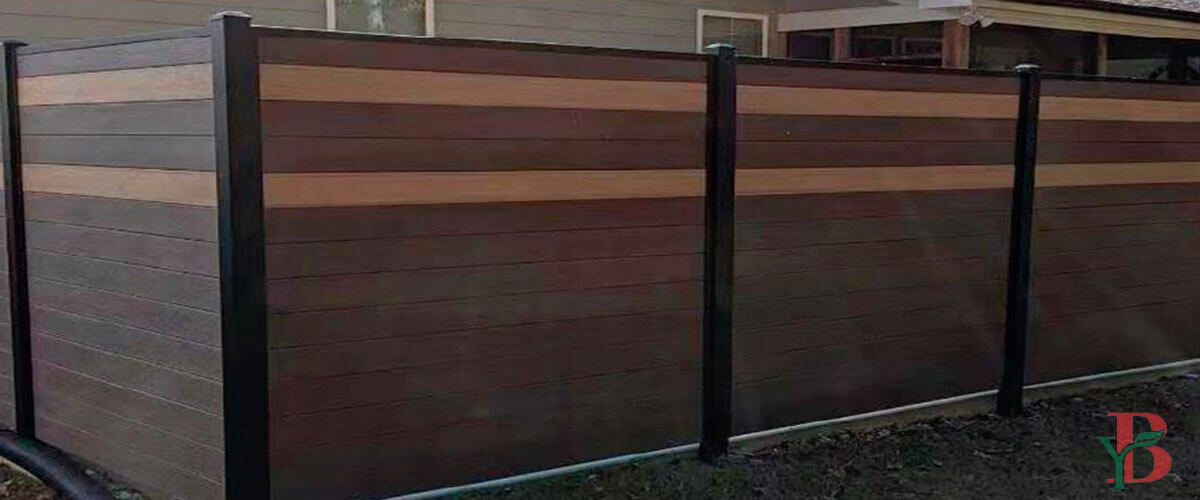 This composite privacy fence combines dark and light horizontal slats for a modern, visually appealing design