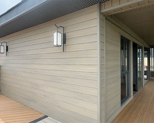 Exterior WPC wall panel cladding on modern house, wood plastic composite siding for outdoor facade